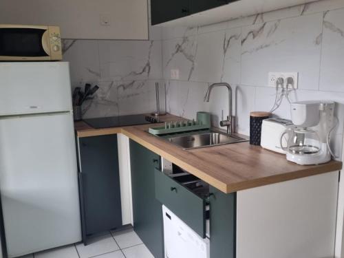 une petite cuisine avec un évier et un réfrigérateur dans l'établissement Chalet Confort à Biscarrosse - 6 Pers. - FR-1-319-594, à Biscarrosse