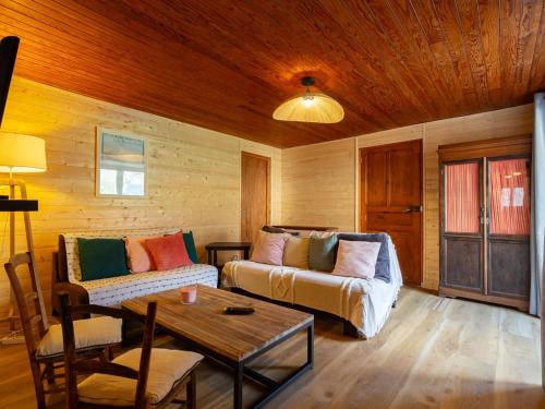 a living room with a couch and a table at Maison à Génos pour 8, proche lac, jardin et poêle à bois - FR-1-695-73 in Génos