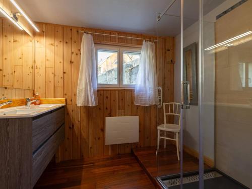 a bathroom with a sink and a window and a shower at Maison à Génos pour 8, proche lac, jardin et poêle à bois - FR-1-695-73 in Génos
