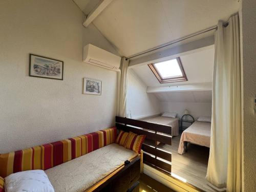 Cette petite chambre comprend un canapé et 2 lits. dans l'établissement Villa 5 pers, Mezzanine, WIFI, Clim, Parking, près Plage - FR-1-81-632, au Barcarès