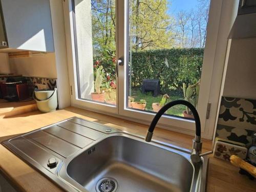 d'un évier dans une cuisine avec une grande fenêtre. dans l'établissement Charmant gîte avec jardin privatif au cœur de la Loire, Wi-Fi & parking inclus - FR-1-381-618, à Montlouis-sur-Loire