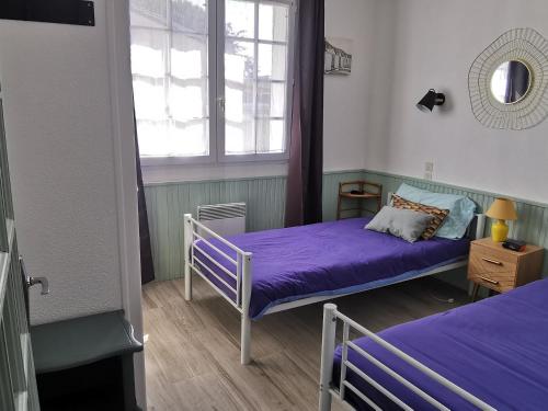 une chambre avec deux lits et une fenêtre dans l'établissement Maison rénovée pour 6 pers. près plage du Bouil, parking privatif - FR-1-194-294, à Saint-Vincent-sur-Jard