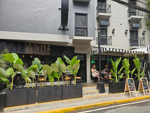 a cafe with tables and chairs in front of a building at Mad Monkey Manila in Manila
