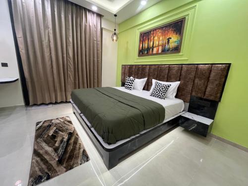 a bedroom with a bed in a green room at Luxuriesstay in Omaxe Hazratganj in Nilmatha