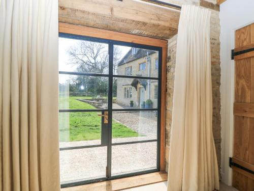 an open glass door with a view of a yard at The Smithy in Stow on the Wold