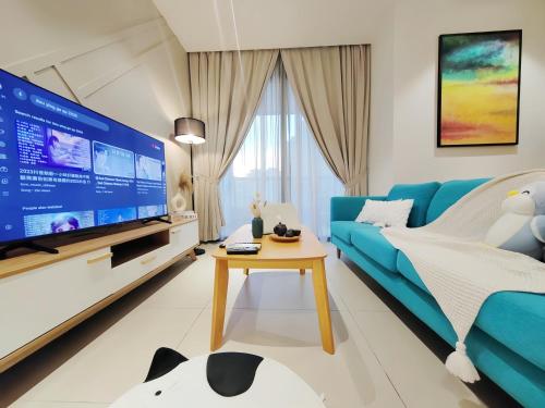 a living room with a blue couch and a tv at Arcoris Mont Kiara in Kuala Lumpur