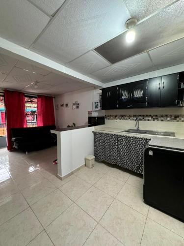 a kitchen with black cabinets and a white counter top at Casa Irene in Chinchiná
