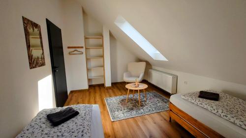 a room with two beds and a chair in it at Cha-lu-pa in Šumperk