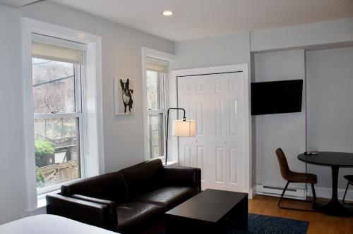 a living room with a leather couch and a table at Stylish Downtown Studio in the SouthEnd, C.Ave# 2 in Boston