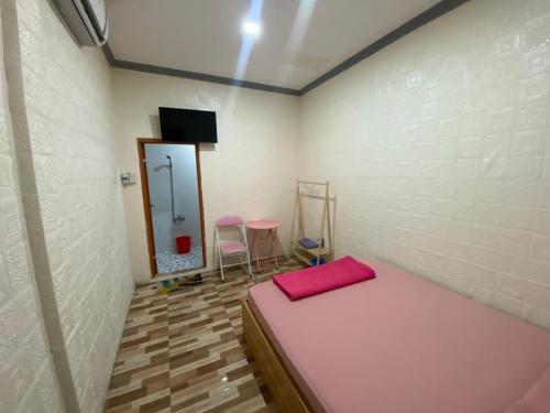 a small room with a bed and a mirror at Nhà Nghỉ Mộc Lan in Ấp Rạch Mẹo