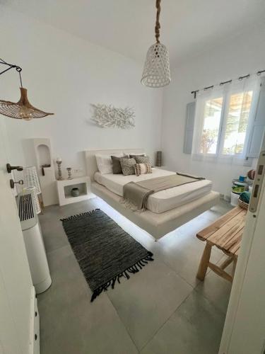 une chambre blanche avec un lit et un tapis dans l'établissement GiSt, à Livadi Astypalaias
