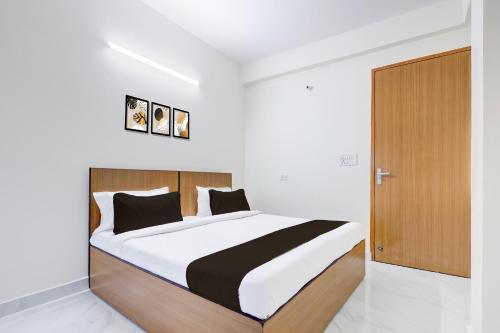 a bedroom with a large bed and a wooden door at Super Hotel O Divine Stay in Gurgaon