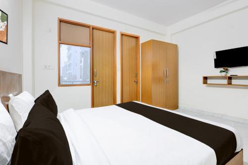 a bedroom with a white bed and wooden cabinets at Super Hotel O Divine Stay in Gurgaon
