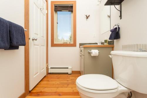 a bathroom with a white toilet and a window at Pet Friendly 3 Bdrm Home with Hot Tub by StayIn in Fernie