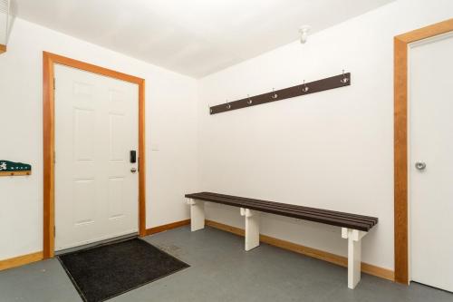 a empty room with a bench next to a door at Pet Friendly 3 Bdrm Home with Hot Tub by StayIn in Fernie