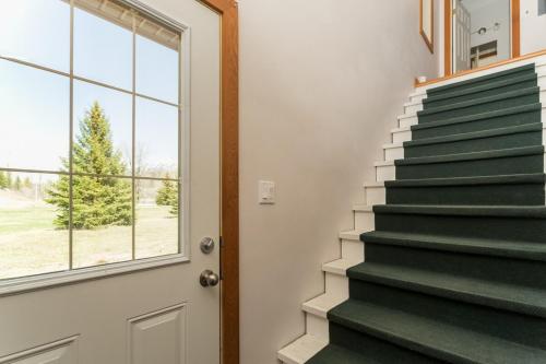 a staircase in a house with a window and a door at Pet Friendly 3 Bdrm Home with Hot Tub by StayIn in Fernie