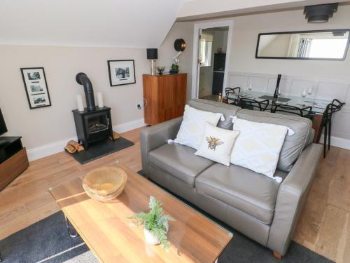 a living room with a couch and a wood stove at Cambrie in Tenby