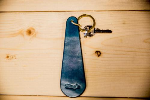 a wooden table with a blue skateboard key chain at Dot Hostel Nagano in Nagano