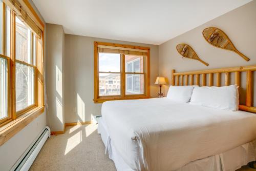 a bedroom with a large white bed and windows at Ski-InandOut Condo with Hot Tub Access in Keystone! in Keystone