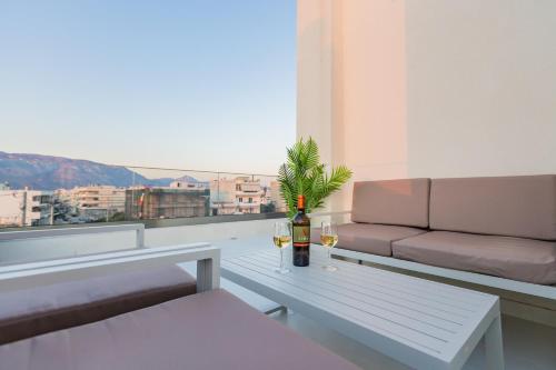 a living room with a couch and a table with wine glasses at BEQUEST Corinthian Luxury suites in Korinthos