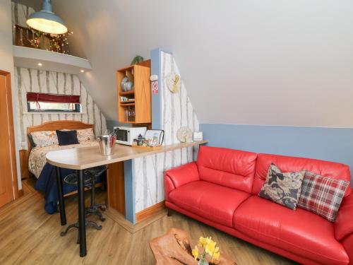 a living room with a red couch and a table at Silver Birch Lodge in Bawtry
