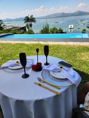 a table with a white table cloth and wine glasses at Le Bamboo Guest House And Boat Cruise in Hartbeespoort
