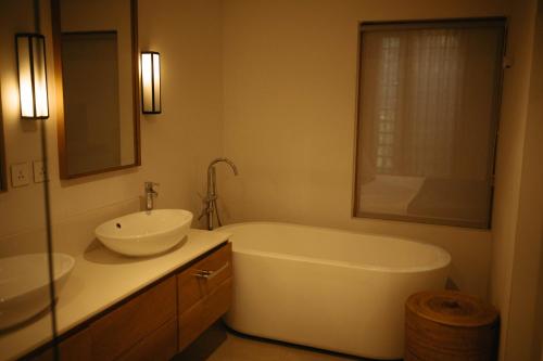 a bathroom with a tub and a sink and a mirror at Le Waterclub Appartement B2 in Belle Vue