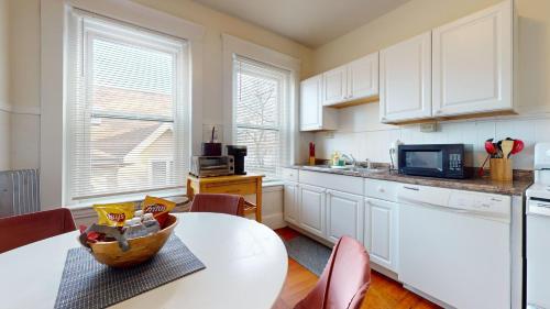 a kitchen with white cabinets and a table with a bowl on it at Sunny,spacious, Sleeps 4, Steps To Mbta,hospitals in Brookline