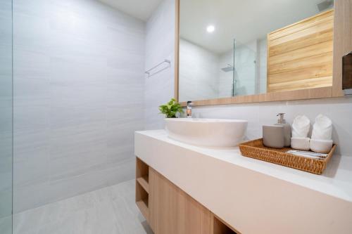 Ban Phru ChampaにあるCoco Villas Phuket - 3 Bedroom Deluxe Garden Pool Villa by Escape Villasの洗面台と鏡のある白いバスルーム