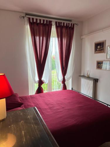 a bedroom with a large purple bed with a window at MaMà - Ma Maison d'Hotes in Vigliano Biellese
