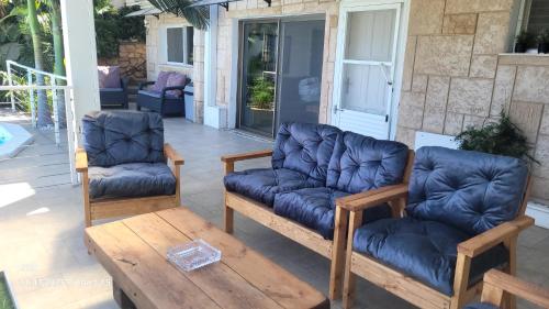 two chairs and a couch on a patio at Beit Nofesh in Tiberias