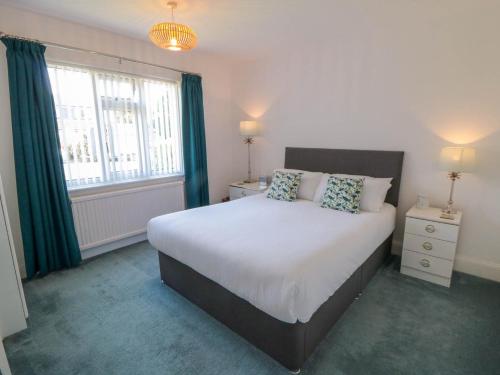 ein Schlafzimmer mit großem Bett und Fenster in der Unterkunft Field Cottage in York