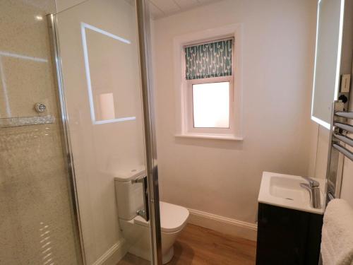 ein Badezimmer mit Toilette und Waschbecken und einem Fenster in der Unterkunft Field Cottage in York