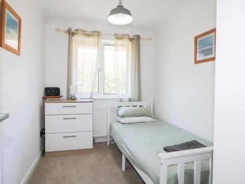 a small bedroom with a bed and a window at 44 West Front Road in Bognor Regis