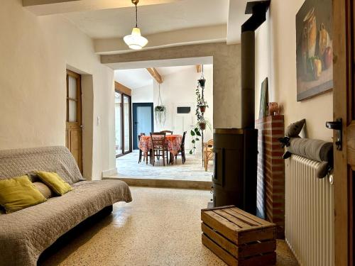 un salon avec un canapé et une salle à manger dans l'établissement Charmante maison de village dans la vallée du lac du Salagou, à Salasc