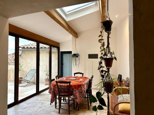 une salle à manger avec une table et quelques chaises dans l'établissement Charmante maison de village dans la vallée du lac du Salagou, à Salasc