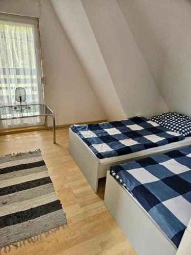 a attic bedroom with two beds and a window at Domek Letniskowy Głebinów in Nysa