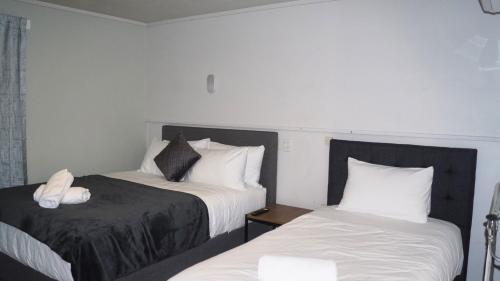 a hotel room with two beds with white pillows at Lavana Motel in Hastings