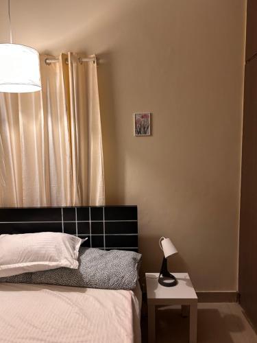 a bedroom with a bed and a lamp on a table at Electrifying 2 BHK Getaway in Bengaluru