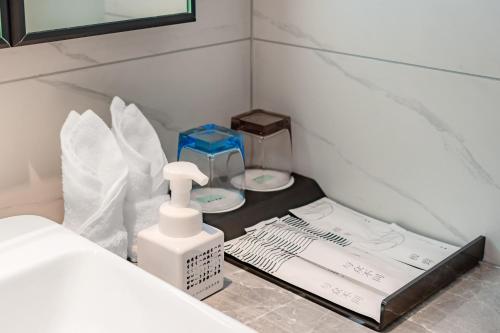 a corner of a room with a sink and a bed at XANA Hotel Qionghai Municipal Government High-speed Railway Station in Qionghai