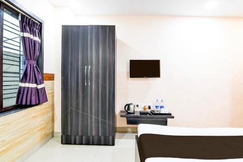 a room with a stainless steel refrigerator and a table at Super Collection O Behala in Kolkata