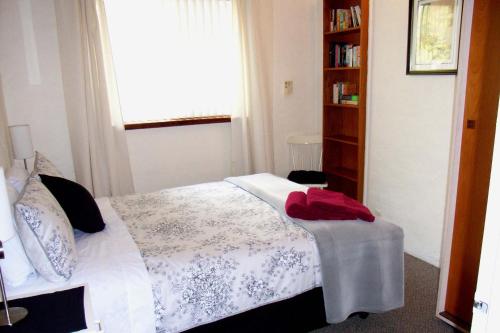a bedroom with a bed and a book shelf at Kenata-Fairway Apartment Hotel in Perth