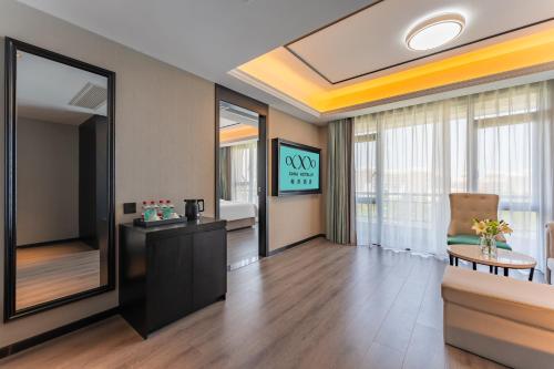 a room with a reception desk and a mirror at XANA Hotel Qionghai Municipal Government High-speed Railway Station in Qionghai
