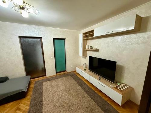 ein Wohnzimmer mit einem großen Flachbildfernseher in der Unterkunft Zen Apartment in Galaţi