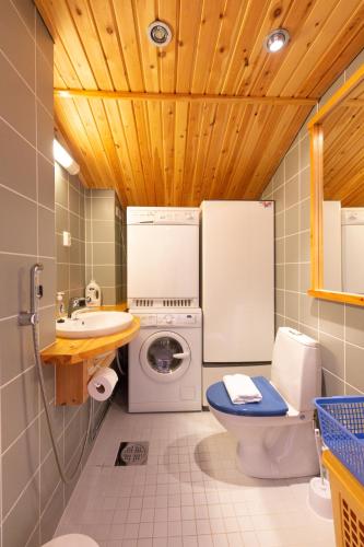 a bathroom with a washing machine and a washer at Vaeltajanmaja in Saariselka