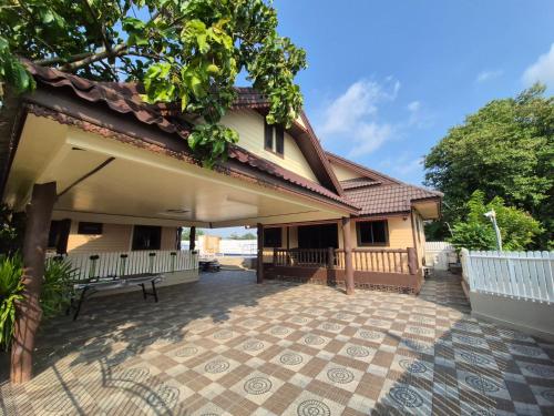 a house with a bench on a patio at 2 Fully equipped Cottages w big Pool & Fishing in Bang Sare
