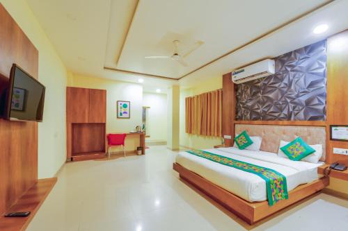 a hotel room with a bed and a television at Treebo Royal Empire Indore in Indore