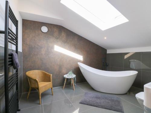baño con bañera grande y silla en The Old Pump House, en Nottingham