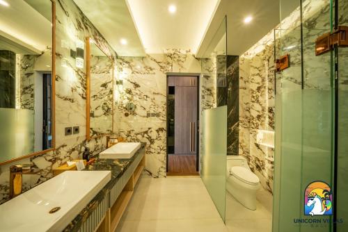a bathroom with a toilet and a sink and a tub at Villa Blissful - by Unicorn Villas Bali in Nusa Dua