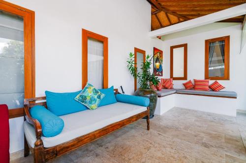 a living room with a couch with blue pillows at Villa Moringa 2 - Private Villa in the Heart of Canggu, 5 Minutes from the Beach in Canggu